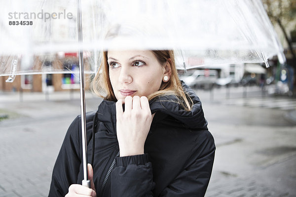 Junge Frau mit transparentem Schirm