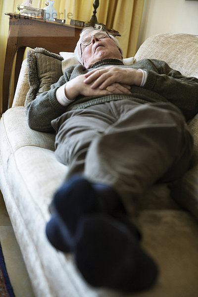 Älterer Mann beim Mittagsschlaf auf dem Sofa