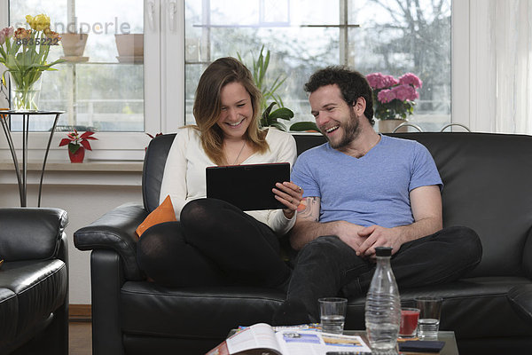 Junges Paar hat Spaß mit dem Tablet-Computer zu Hause