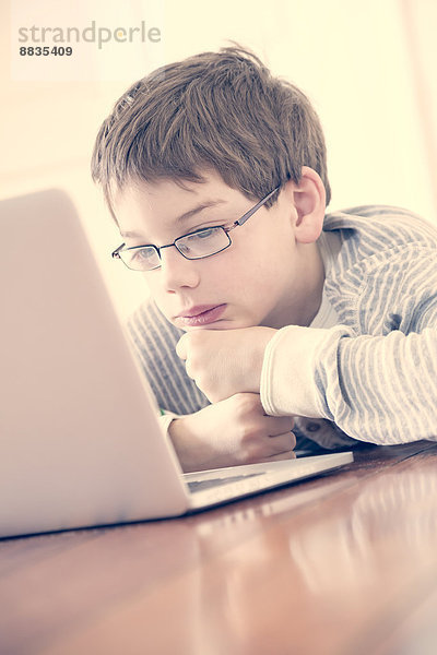 Porträt des Jungen mit Laptop zu Hause