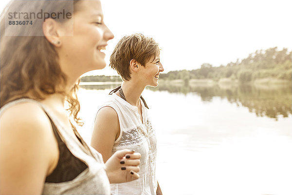 Porträt von zwei jungen Frauen  die sich am Baggersee amüsieren