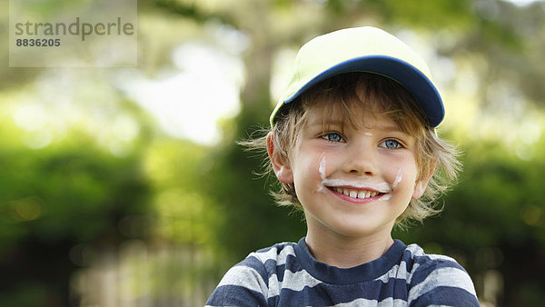 Porträt eines lächelnden kleinen Jungen mit Milchbart