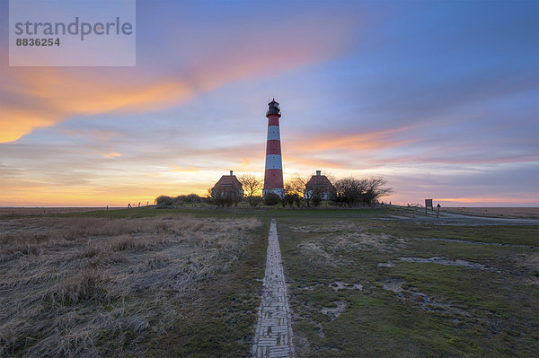 Deutschland  Schleswig-Holstein  Nordseeküste  Blick auf Westerheversand Leuchtturm bei Sonnenuntergang