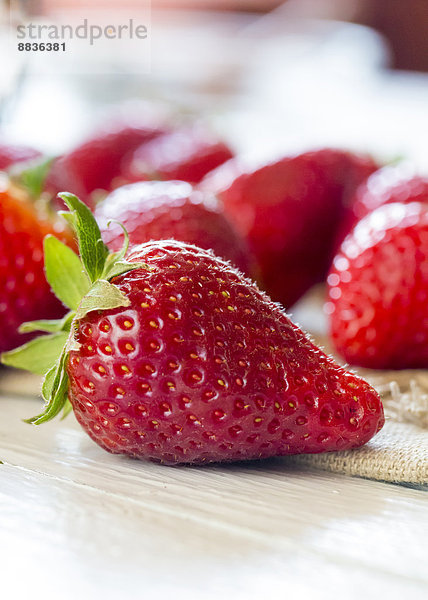 Erdbeeren auf Tuch und Holztisch