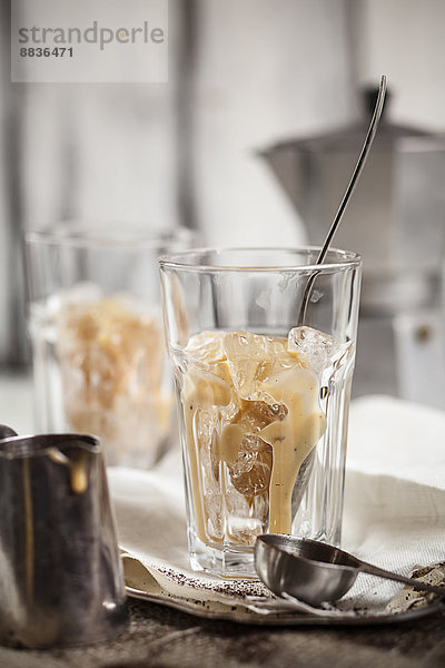 Süße Kondensmilch im mit Eis gefüllten Trinkglas