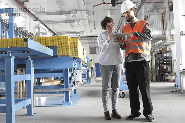 Techniker und Ingenieur in einer Fabrikhalle