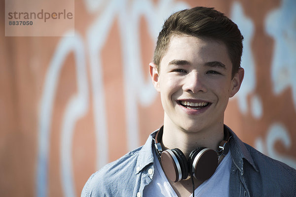 Porträt eines lächelnden Teenagers mit Kopfhörer