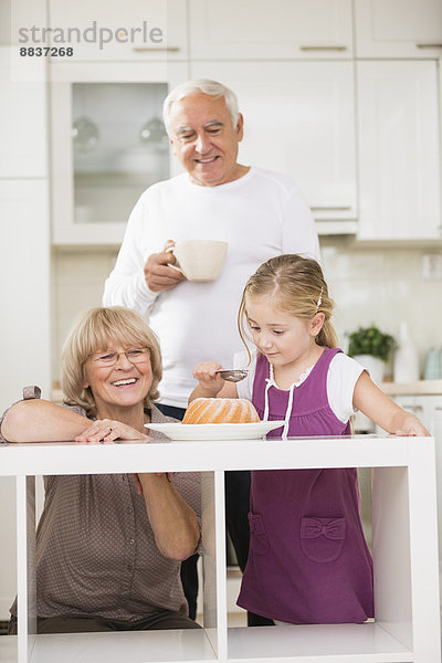 Seniorenpaar mit Enkelin in der Küche