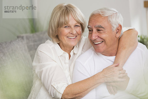 Glückliches Seniorenpaar zusammen im Wohnzimmer
