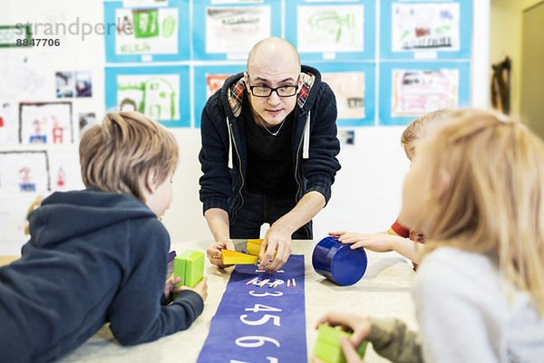 Lehrerin mit Schülern in der Kunstklasse im Kindergarten