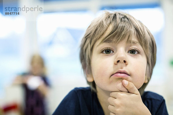 Kleiner Junge schaut weg im Kindergarten