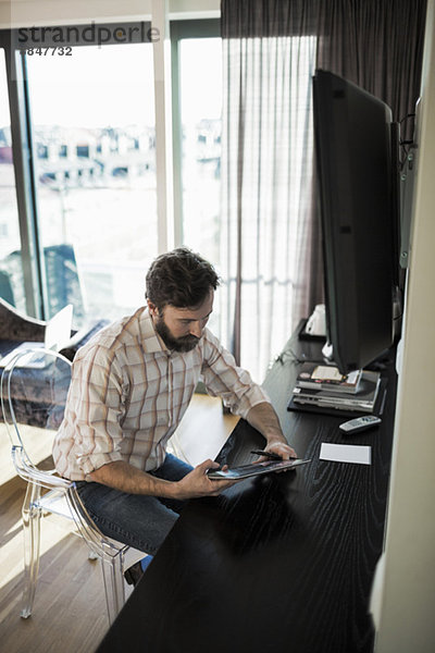 Geschäftsmann mit digitalem Tablett im Hotelzimmer