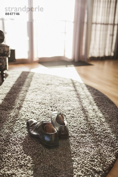 Paar formelle Schuhe auf Teppich im Hotelzimmer