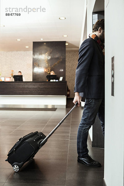 Geschäftsmann mit Gepäckaufzug im Hotel