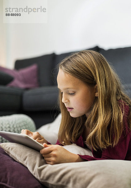 Mädchen mit digitalem Tablett im Wohnzimmer