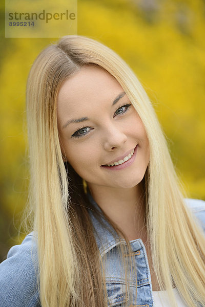 Junge blonde Frau in einem Park im Frühling