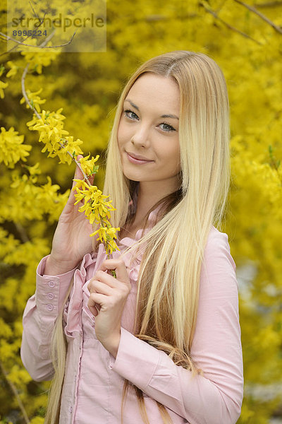 Junge blonde Frau in einem Park im Frühling