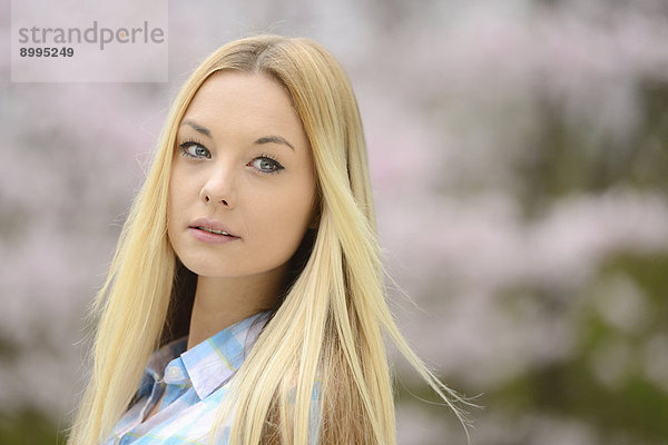 Junge blonde Frau in einem Park im Frühling