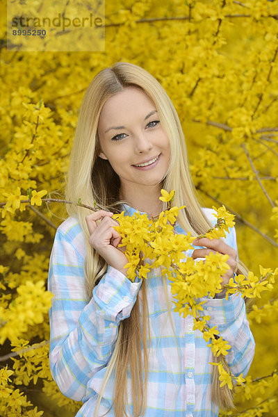 Junge blonde Frau in einem Park im Frühling