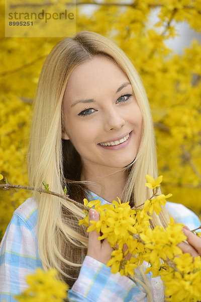 Junge blonde Frau in einem Park im Frühling