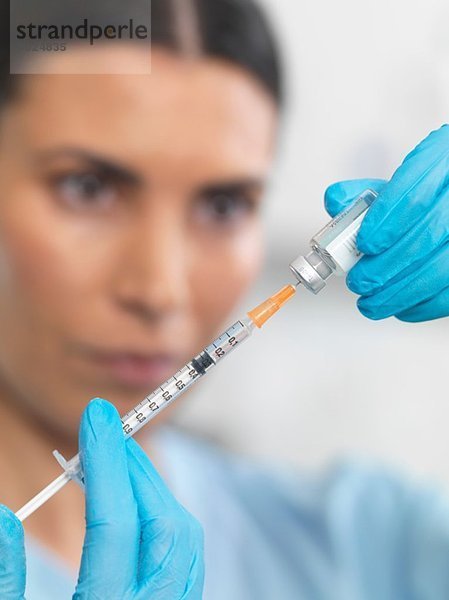 Krankenschwester bereitet eine Spritze für eine Injektion vor