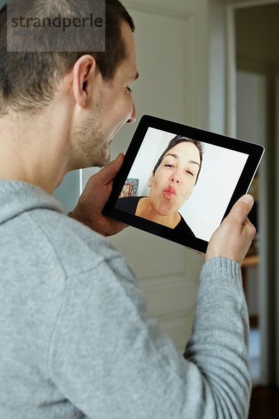 Mittlerer Erwachsener Mann  der mit dem Bildschirm eines digitalen Tabletts interagiert