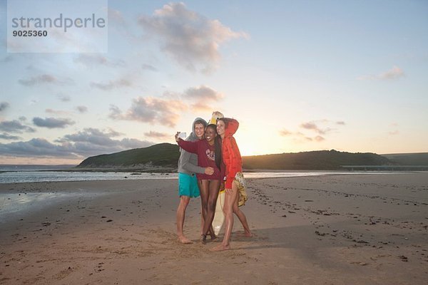 Freunde am Strand beim Selbstporträtfotografieren