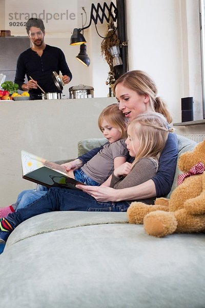 Mutter und zwei Töchter lesen Märchenbuch