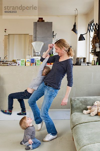 Mittlere erwachsene Mutter  die mit ihren beiden jungen Töchtern spielt.