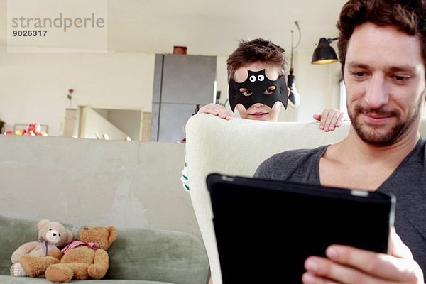 Maskierter Sohn lenkt Vater vom digitalen Tablett ab