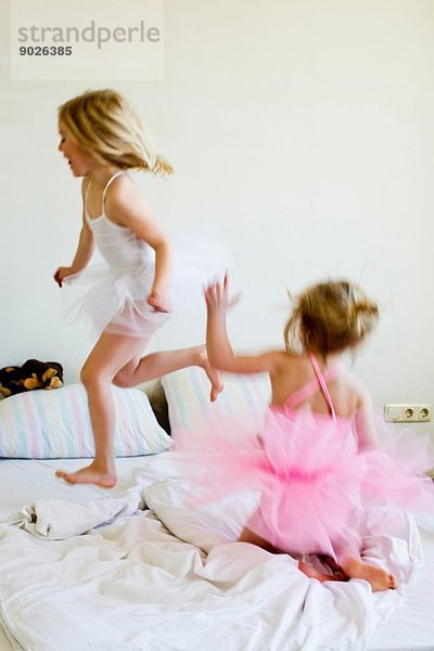 Schwestern als Balletttänzerinnen auf dem Bett verkleidet