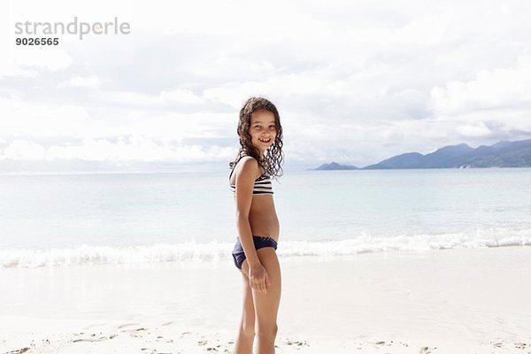 Mädchen steht am Strand der Seychellen