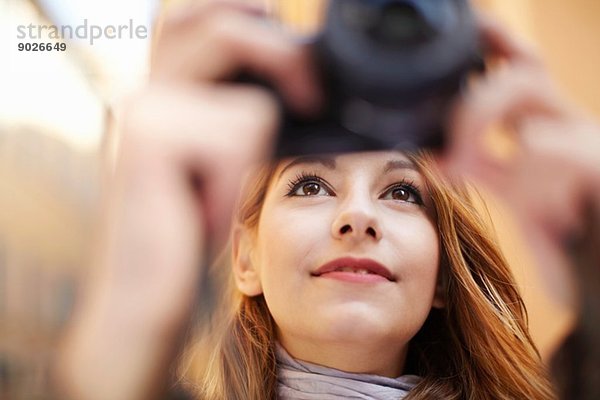 Nahaufnahme der jungen Frau beim Fotografieren mit der Digitalkamera