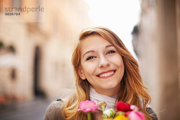 Lächelnde junge Frau mit einem Blumenstrauß