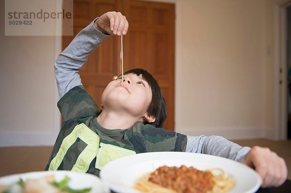 Junge spielt mit Spaghetti