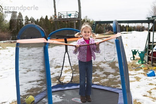Porträt eines jungen Mädchens  das auf einem Trampolin im Park springt.
