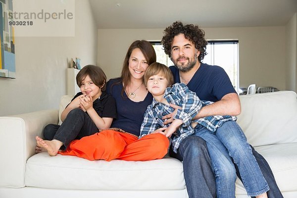 Porträt der Familie mit zwei Jungen auf dem Sofa