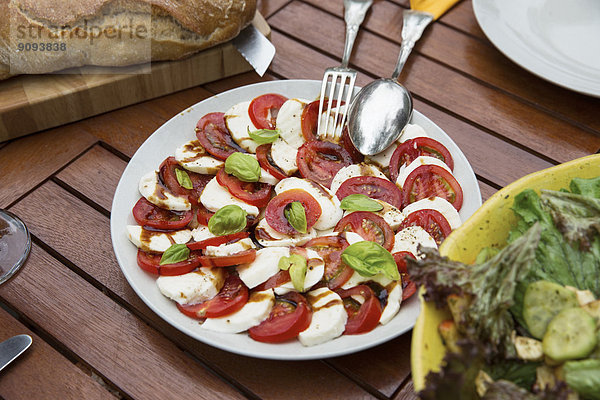 Tomate mit Mozzarella und Basilikum auf dem Teller