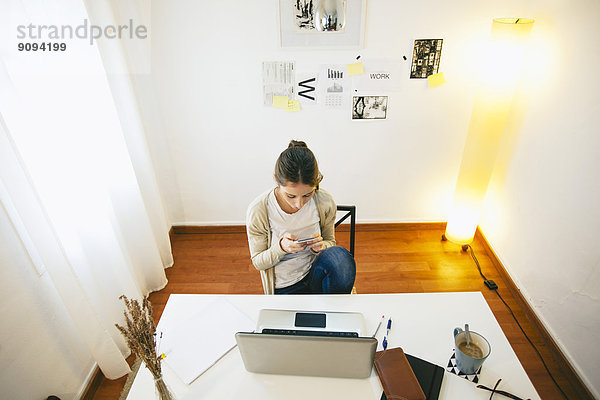 Frau mit Smartphone im modernen Home-Office  erhöhte Ansicht