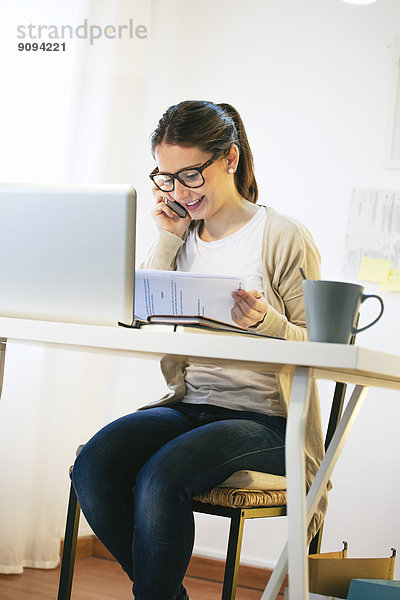 Porträt der Frau beim Telefonieren mit dem Smartphone im modernen Home Office