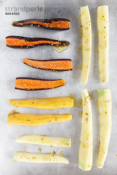 Verschiedene Sorten von ganzen und in Scheiben geschnittenen marinierten Karotten auf Metall  erhöhte Ansicht