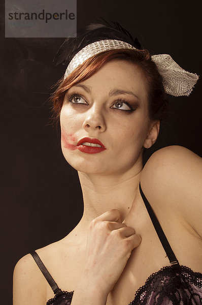 Bildnis einer jungen Frau mit Lippenstift auf der Wange im Stil der 20er Jahre