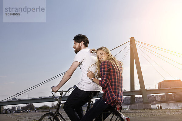 Glückliches Paar beim Fahrradfahren am Flussufer