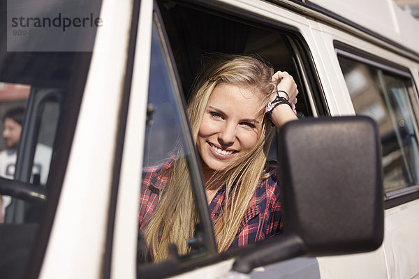 Lächelnde junge Frau im Minivan
