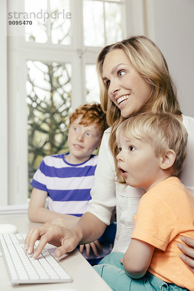 Glückliche Mutter mit zwei Söhnen auf dem Computerbildschirm