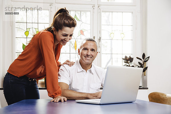 Erwachsener Mann und junge Frau mit Laptop zu Hause
