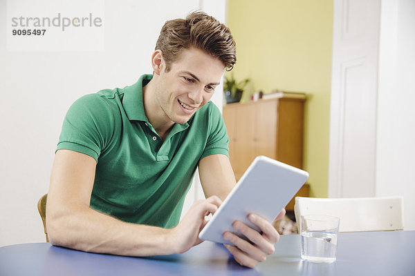 Porträt eines jungen Mannes mit Tablet-Computer zu Hause
