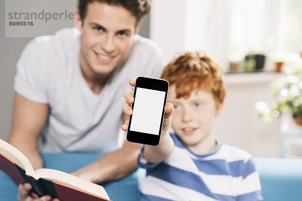Vater und Sohn mit Buch und Smartphone
