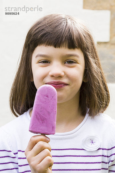 Porträt eines kleinen Mädchens mit Joghurt Blaubeereis Lolly