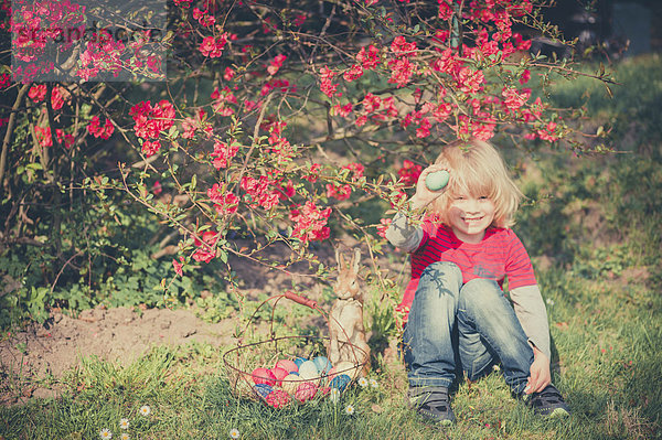 Junge im Garten mit Osterei